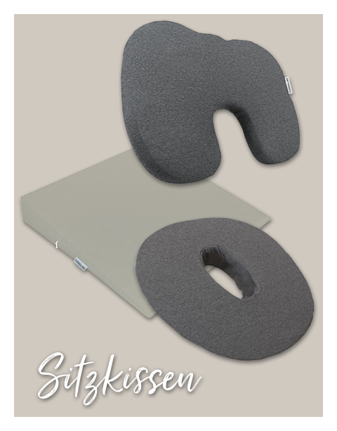 Graue, ergonomische Sitzkissen in verschiedenen Formen (U-förmig, rund mit Loch) liegen vor einem beigen, quadratischen Kissen. Text: \